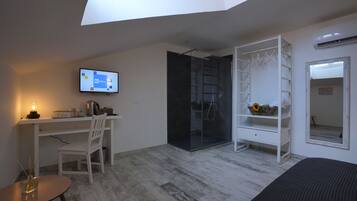 Une chambre moderne avec un puits de lumière, un bureau avec un ordinateur, une chaise, un lit, une armoire et un miroir.