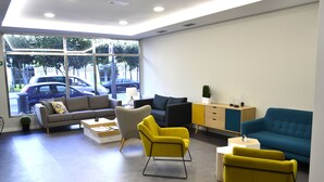Een moderne woonkamer met een bank, fauteuils en een salontafel.