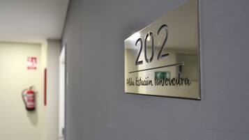 A metallic sign with the number 202 and the text "Ala Estacion Longevica" on a wall.