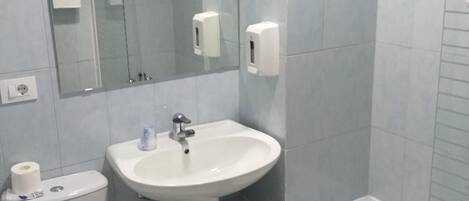 Un baño con inodoro, lavamanos y bañera.