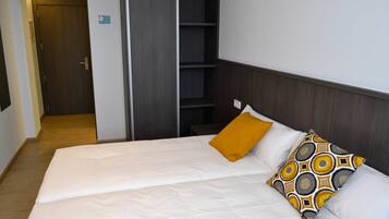 Ein Hotelzimmer mit Bett, Kleiderschrank und einer kleinen Sitzecke.