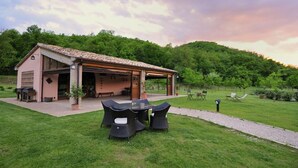 Une maison dotée d’un patio couvert, d’un espace salon extérieur et d’une pelouse verdoyante.