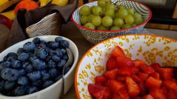 Three bowls of fruit: blueberries, grapes, and strawberries.