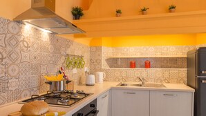 A kitchen with patterned tiles, a stove, a sink, and a refrigerator. - Pilastri Garden by Mmega (Florence)