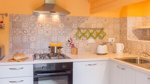 A modern kitchen with a gas stove, oven, and a variety of kitchen appliances. - Pilastri Garden by Mmega (Florence)