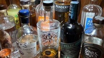 Varias botellas de licor sobre una superficie de madera, con un espejo al fondo.