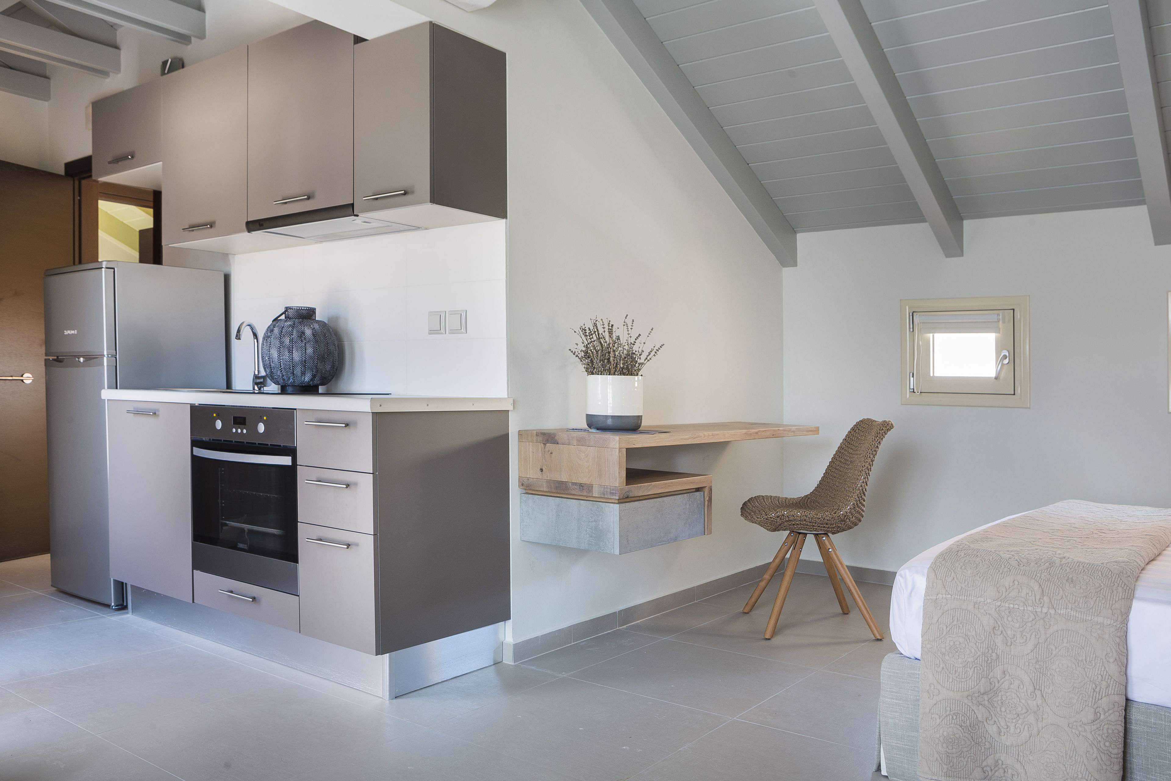 A modern kitchen with built-in appliances, a wooden dining area, and a cozy seating space.
