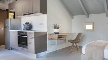 Une cuisine moderne dotée d’appareils électroménagers intégrés, un coin repas en bois et un espace salon confortable.
