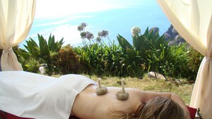A person receiving a massage outdoors with a scenic ocean view. - Hotel Jardim Atlantico (Calheta)