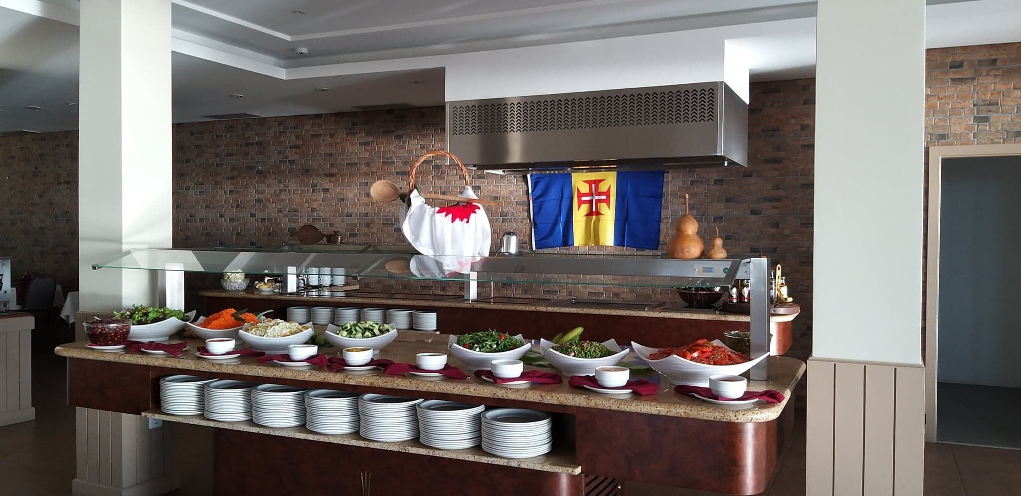 A buffet setup with various dishes and a chef in the background.