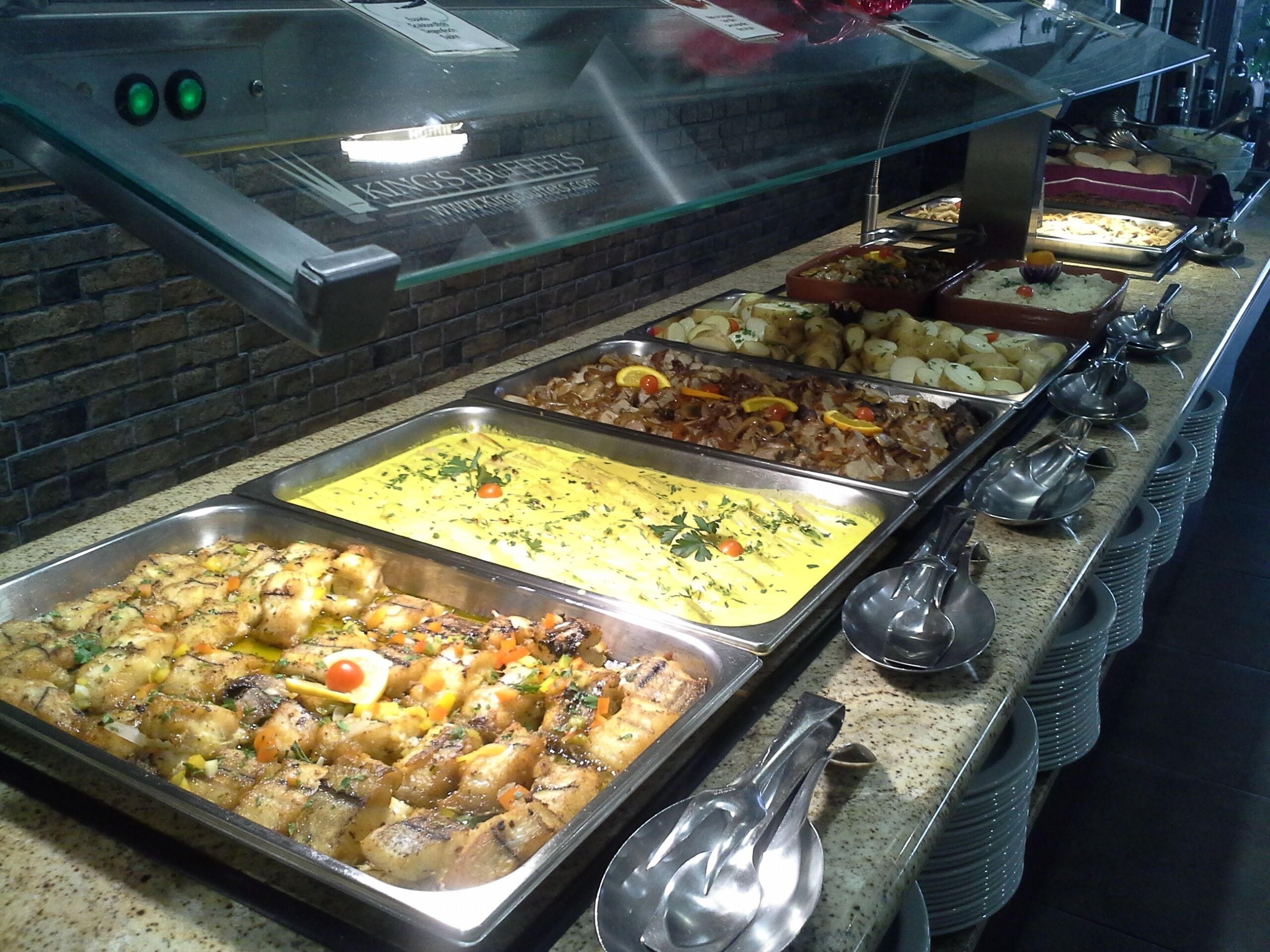A buffet with various dishes including roasted chicken, rice, and vegetables.
