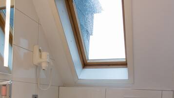 Ein kleines, modernes Badezimmer mit Oberlicht, Toilette und Waschbecken.