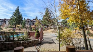 A residential area with a paved walkway, a wooden deck, and a swimming pool. - Great Complex Amenities Available, Near Biking & Walking Trails, Summer Pool (Mammoth Lakes)