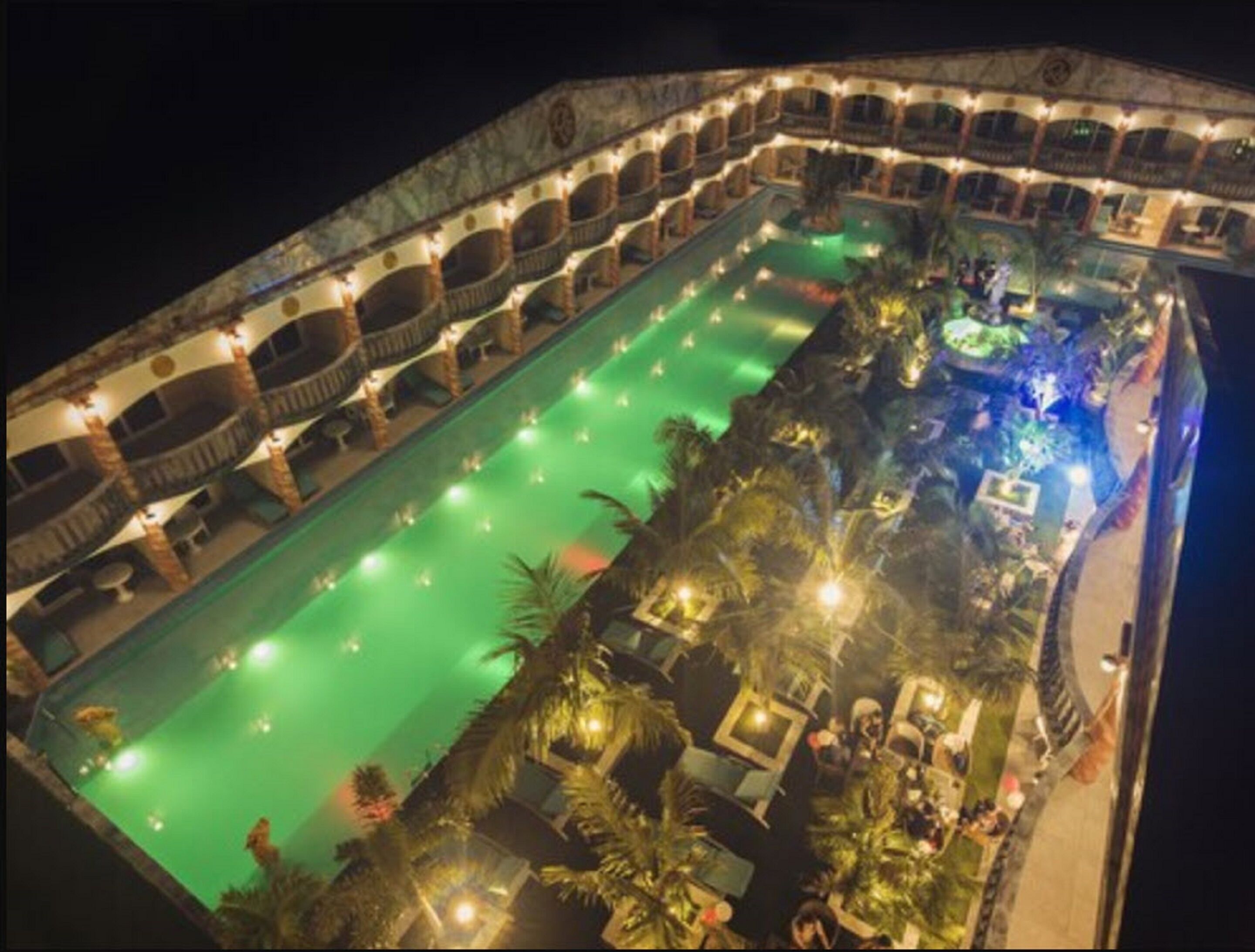 A large indoor swimming pool with multiple levels of balconies and seating areas.