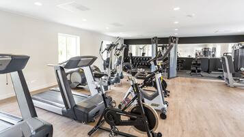 A gym with treadmills, elliptical machines, and weight equipment.