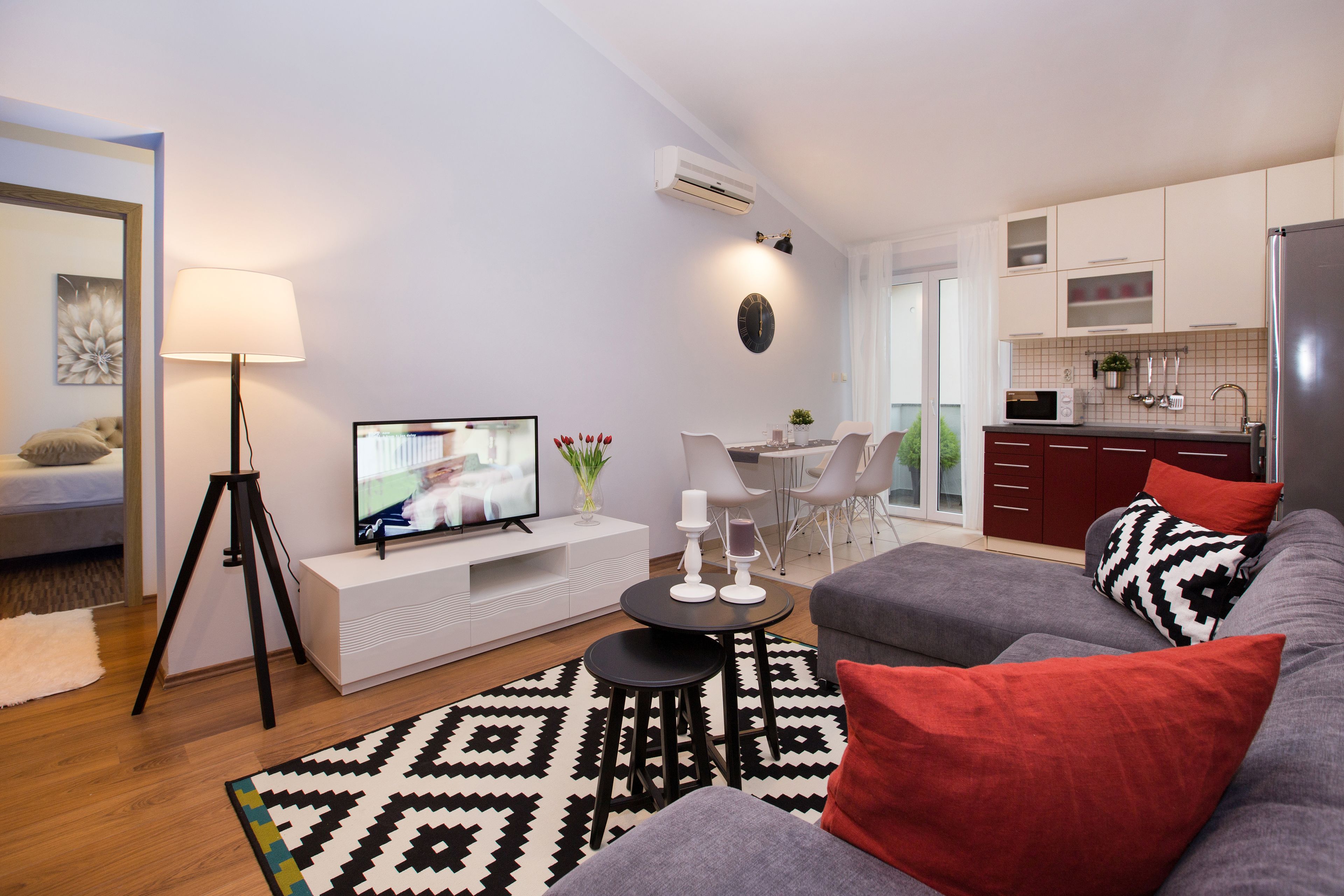 Un salon moderne avec un canapé, un téléviseur et un coin repas.