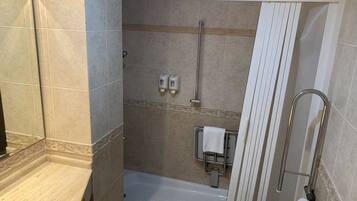 Une salle de bain avec douche, toilettes et lavabo.