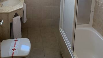 A bathroom with a sink, a toilet, and a shower.