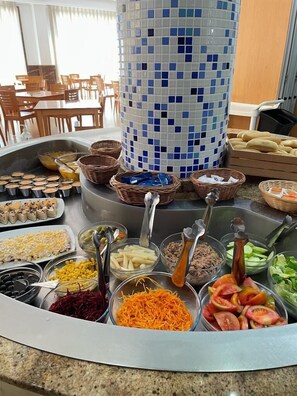 Een buffet met diverse gerechten en bestek.
