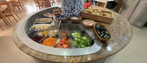 A buffet area with various food items and a central decorative column.