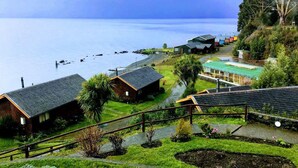 A coastal property with multiple buildings, a pathway, and a view of the sea.