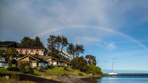 A coastal property with houses, a dock, and a boat.