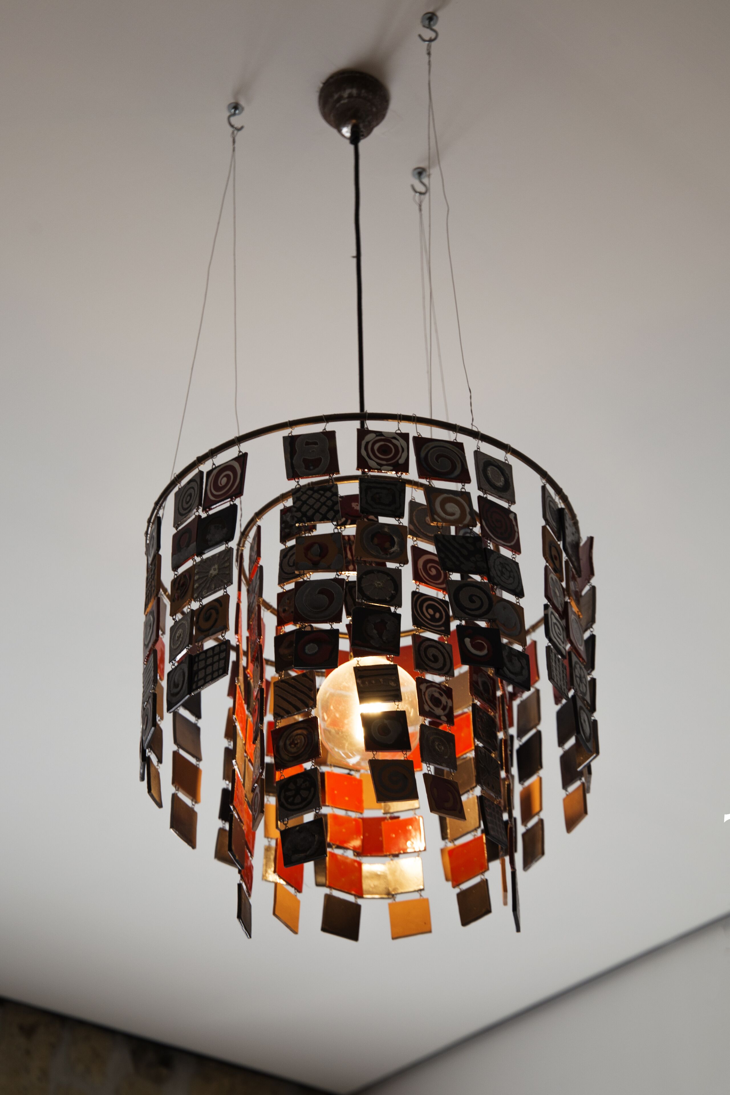 A circular chandelier with multiple square elements and a central light source.