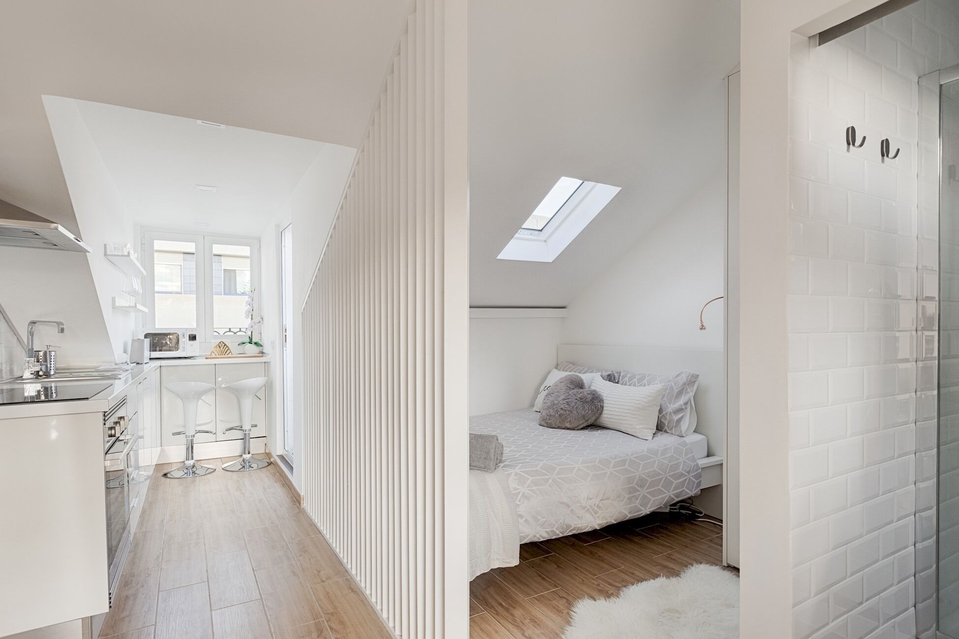 Un apartamento moderno y compacto con cocina, comedor, un dormitorio con tragaluz y baño.