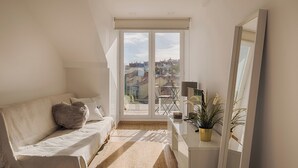 A modern living room with a sofa, a small table, and a potted plant. - Romantic Gem in Alcântara (Lisboa)