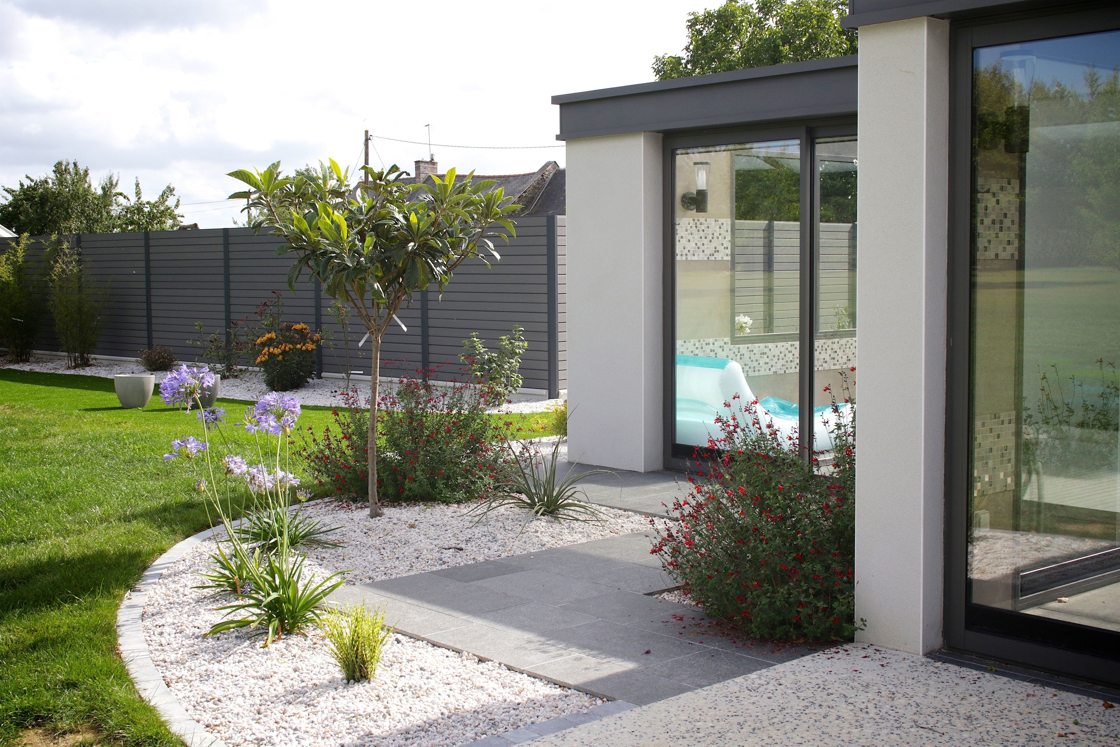 A modern house with a well-maintained garden, a swimming pool, and a patio area.