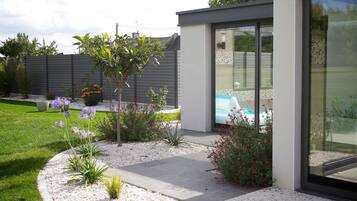 A modern house with a well-maintained garden, a swimming pool, and a patio area.
