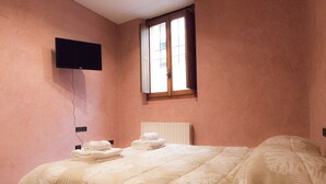 A bedroom with a bed, a window, a wall-mounted TV, and a radiator. - Casa Bella Riva Reno - In the Heart of Bologna (Bologna)