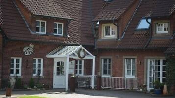 Traditional brick building with a central entrance and well-manicured lawn.