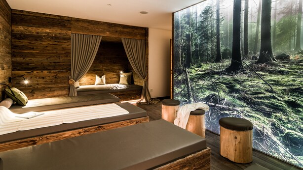A modern bedroom with a large forest mural, a cozy bed, and a wooden accent wall. - Hotel Regglbergerhof (Nova Ponente)