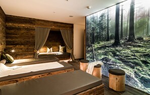 A modern bedroom with a large forest mural, a cozy bed, and a wooden accent wall. - Hotel Regglbergerhof (Nova Ponente)