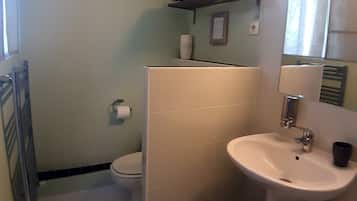 A bathroom with a toilet, sink, and a towel rack.