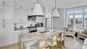 A modern kitchen with white cabinets, a marble island, and pendant lighting. - Private pool. gulf views, great large Seagrove beach home (Santa Rosa Beach)