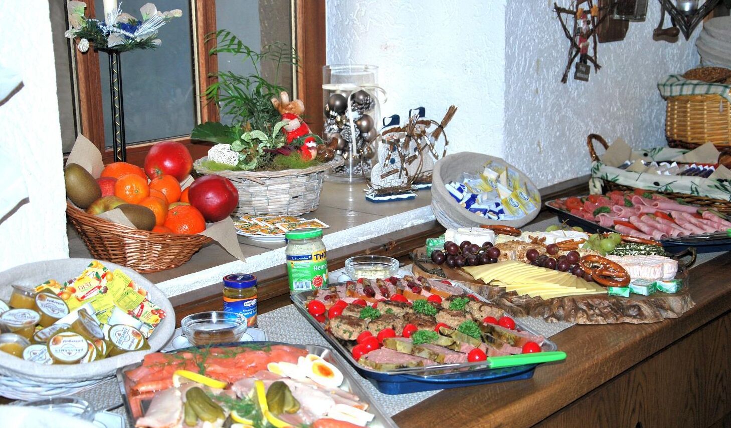 Ein Buffet mit einer Auswahl an Speisen, darunter Früchte, Käse, Fleisch und Soßen.