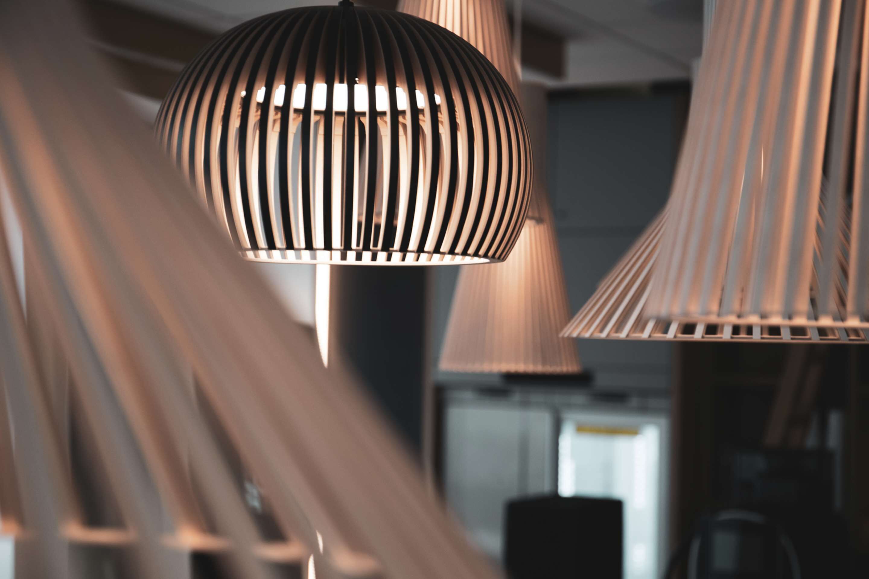Ein modernes Interieur mit mehreren hängenden Pendelleuchten mit Rillenmuster.