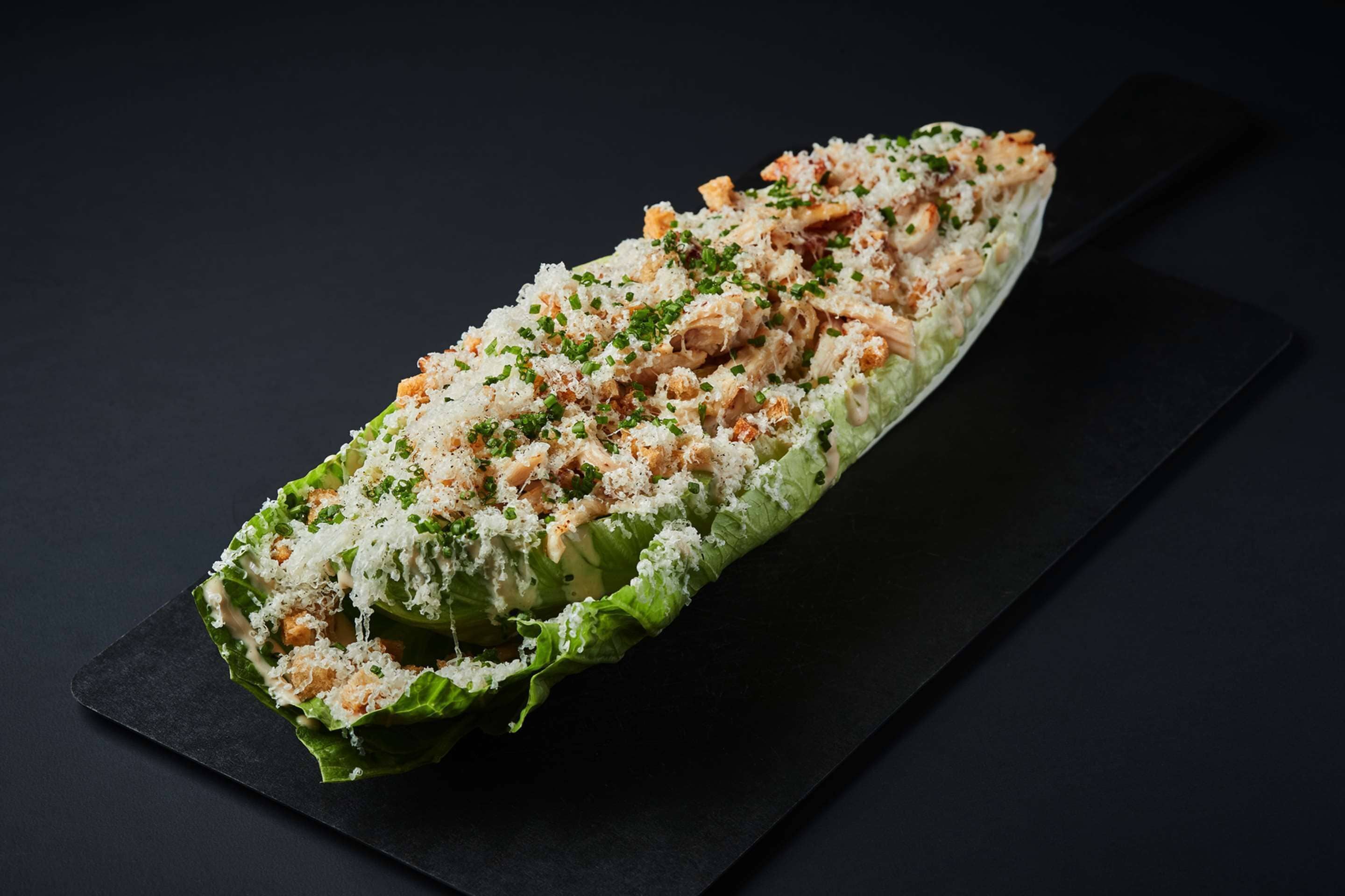 Een schotel met zeevruchtensalade in een la blad, gepresenteerd op een zwarte leisteen plaat.