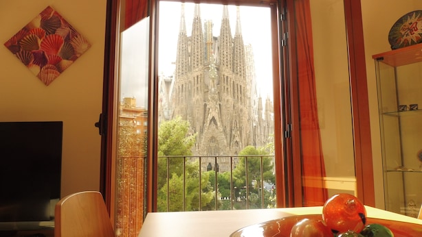 A room with a large window overlooking a cathedral. - Absolute Sagrada Familia (Barcelona)