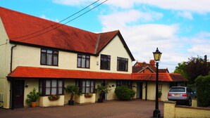 A two-story building with a red-tiled roof and a brick-paved courtyard. - High Hedges Apartments (Oxford)