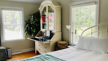 Une chambre à coucher avec un lit, une commode et une plante.