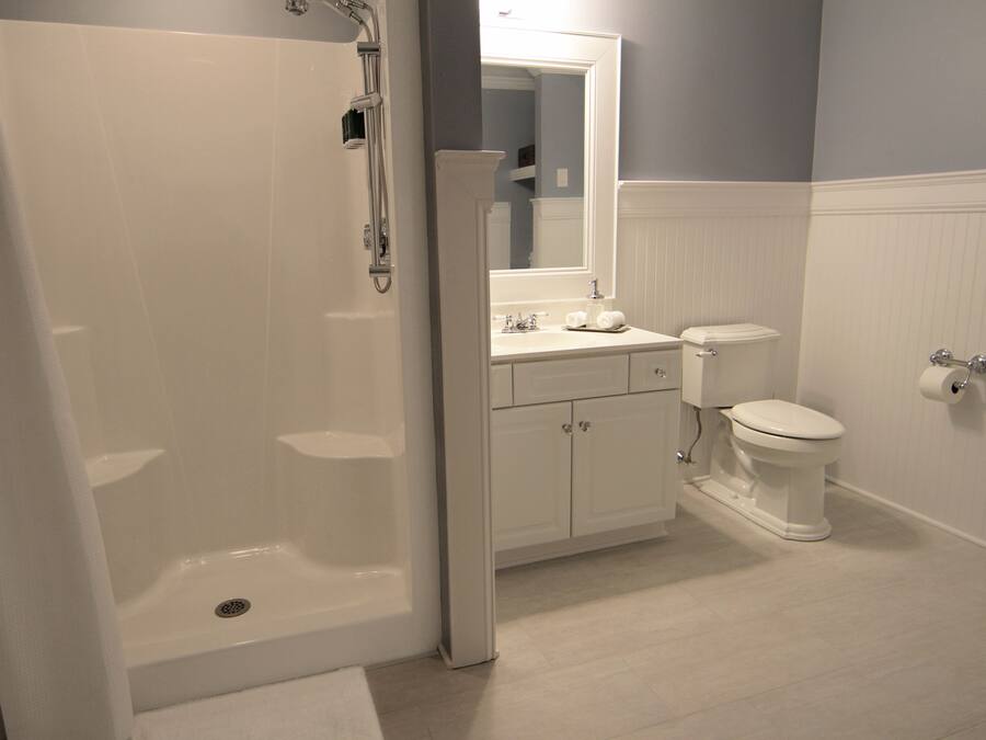 Un bagno con doccia a pavimento, un water e un lavandino.