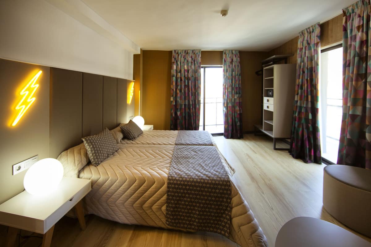 A modern bedroom with a bed, bedside table, and a lamp.
