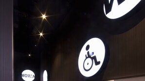 A hallway with signs indicating a women's restroom and a wheelchair-accessible restroom. - Hotel Cuco (Benidorm)