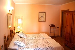 A bedroom with two beds, a nightstand with a lamp, a framed picture on the wall, and a wooden wardrobe. - El Olivo de Sansol (Sansol)
