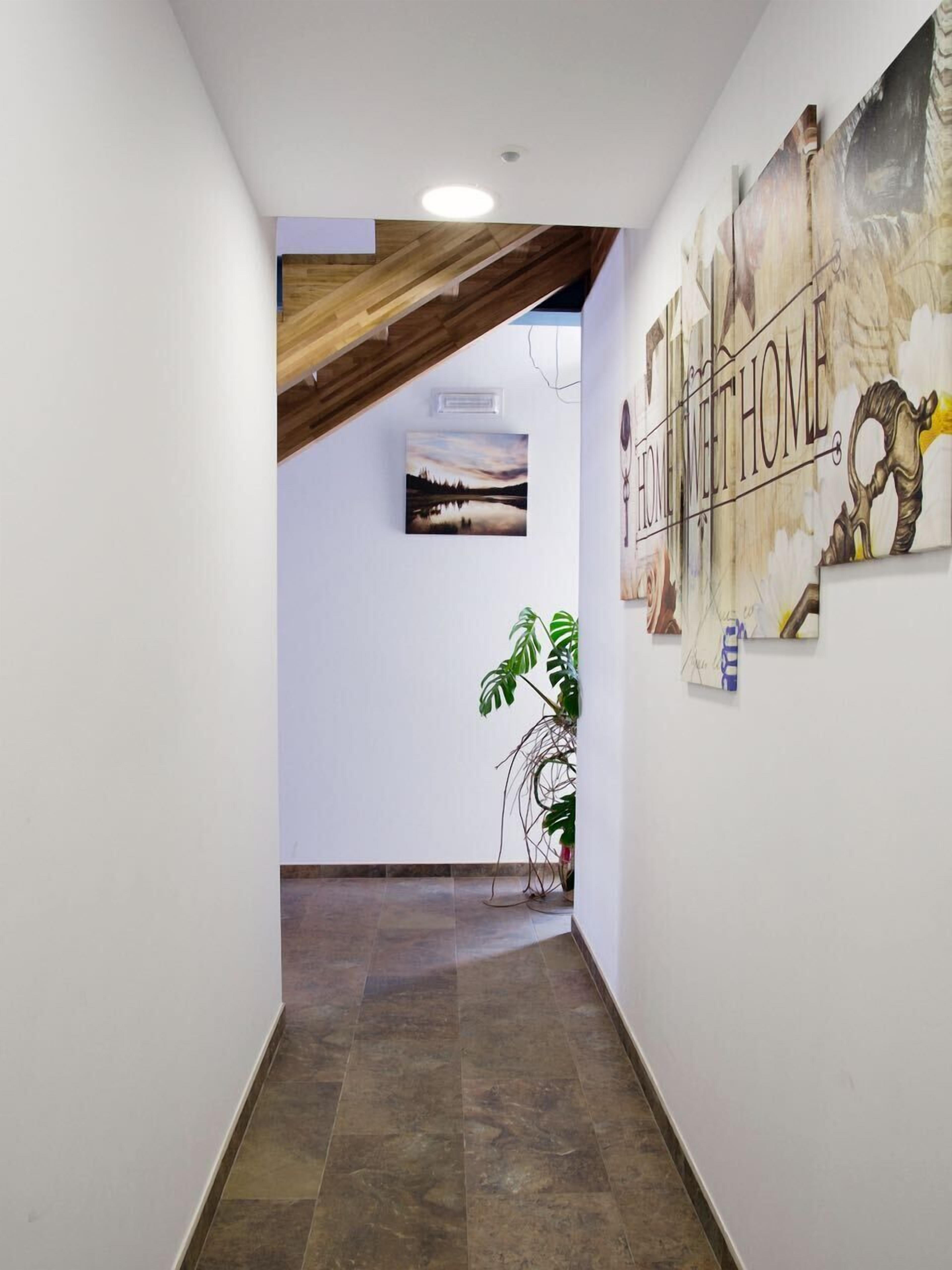 A hallway with a wooden ceiling, a mural with the text "HOME MEET HOME", and a framed picture on the wall.