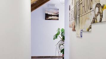 A hallway with a wooden ceiling, a mural with the text "HOME MEET HOME", and a framed picture on the wall.
