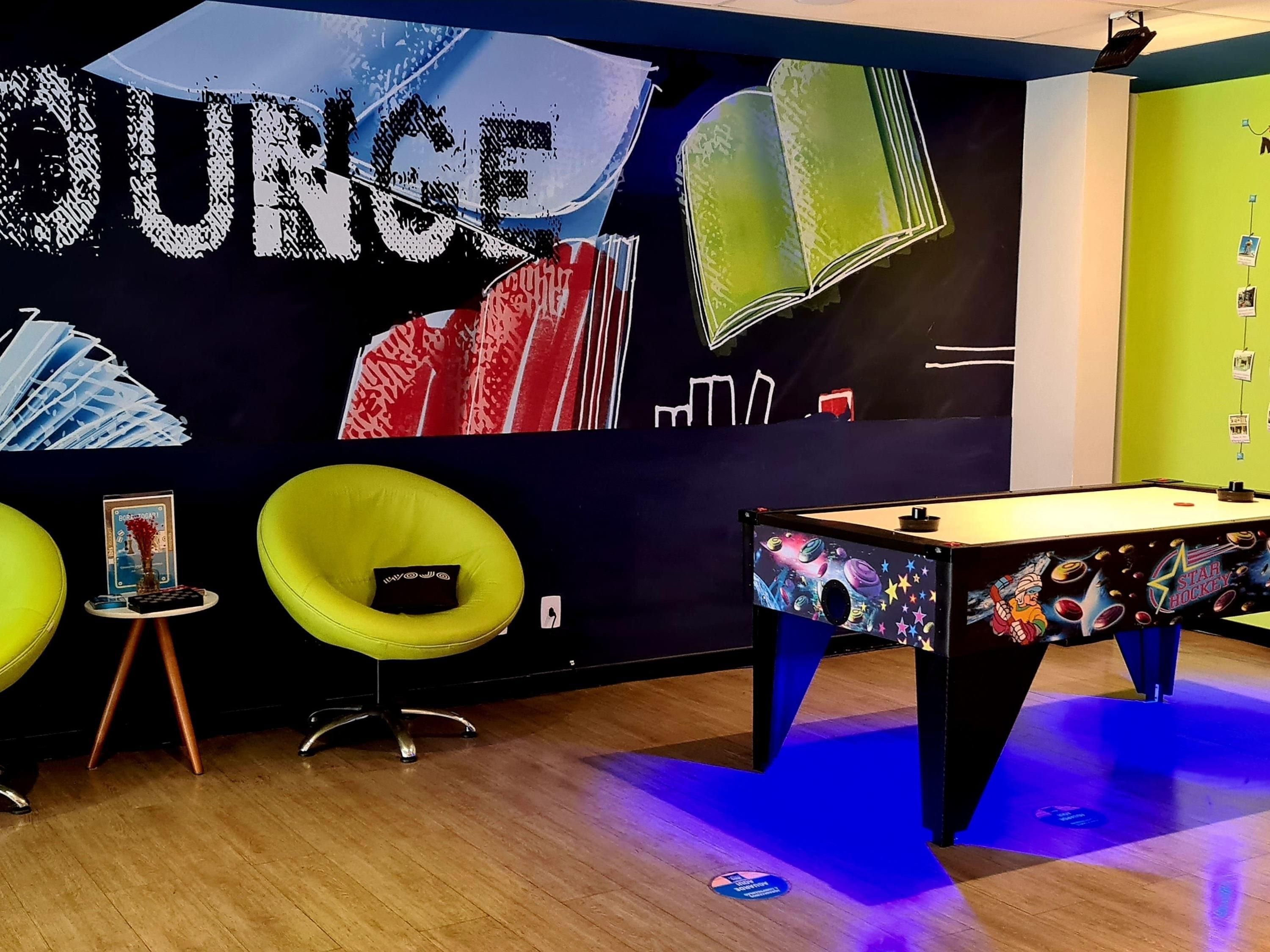 Una habitación con mesa de billar, luces de neón y una pared decorada con temática de Star Trek.